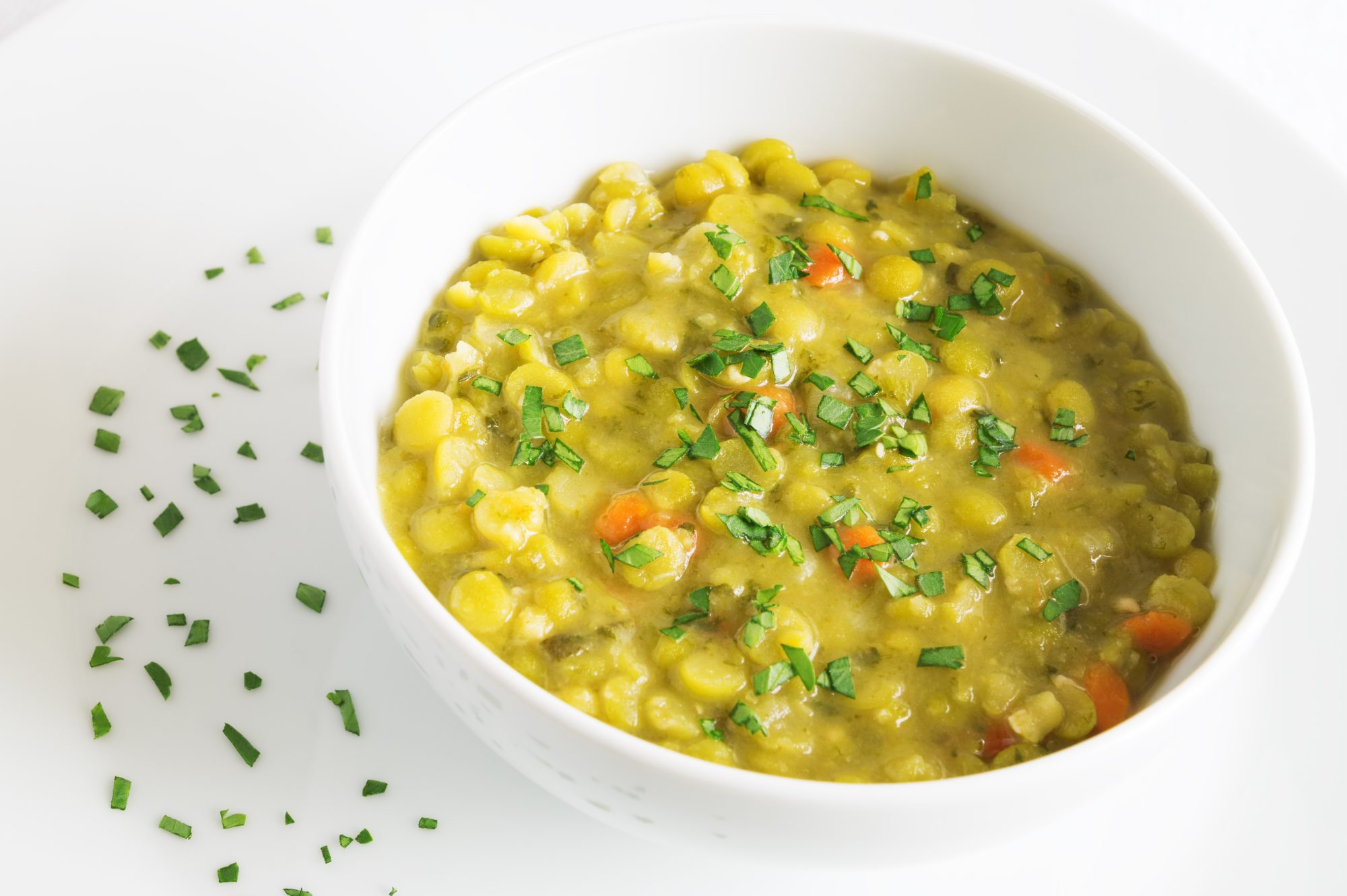 pea soup in a white bowl decorated with parsley